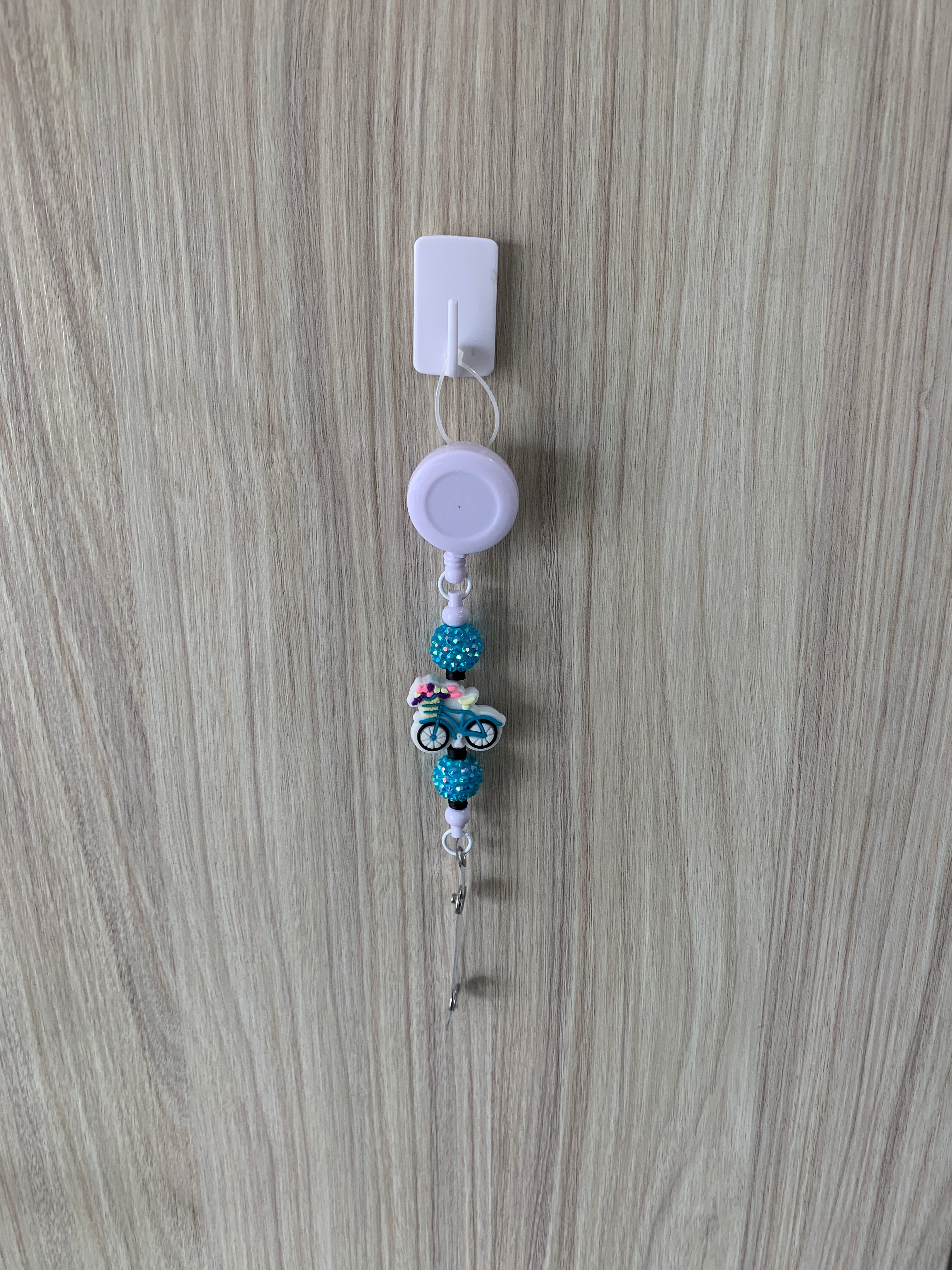 Handmade teal and white bicycle beaded belt clip with floral basket charm