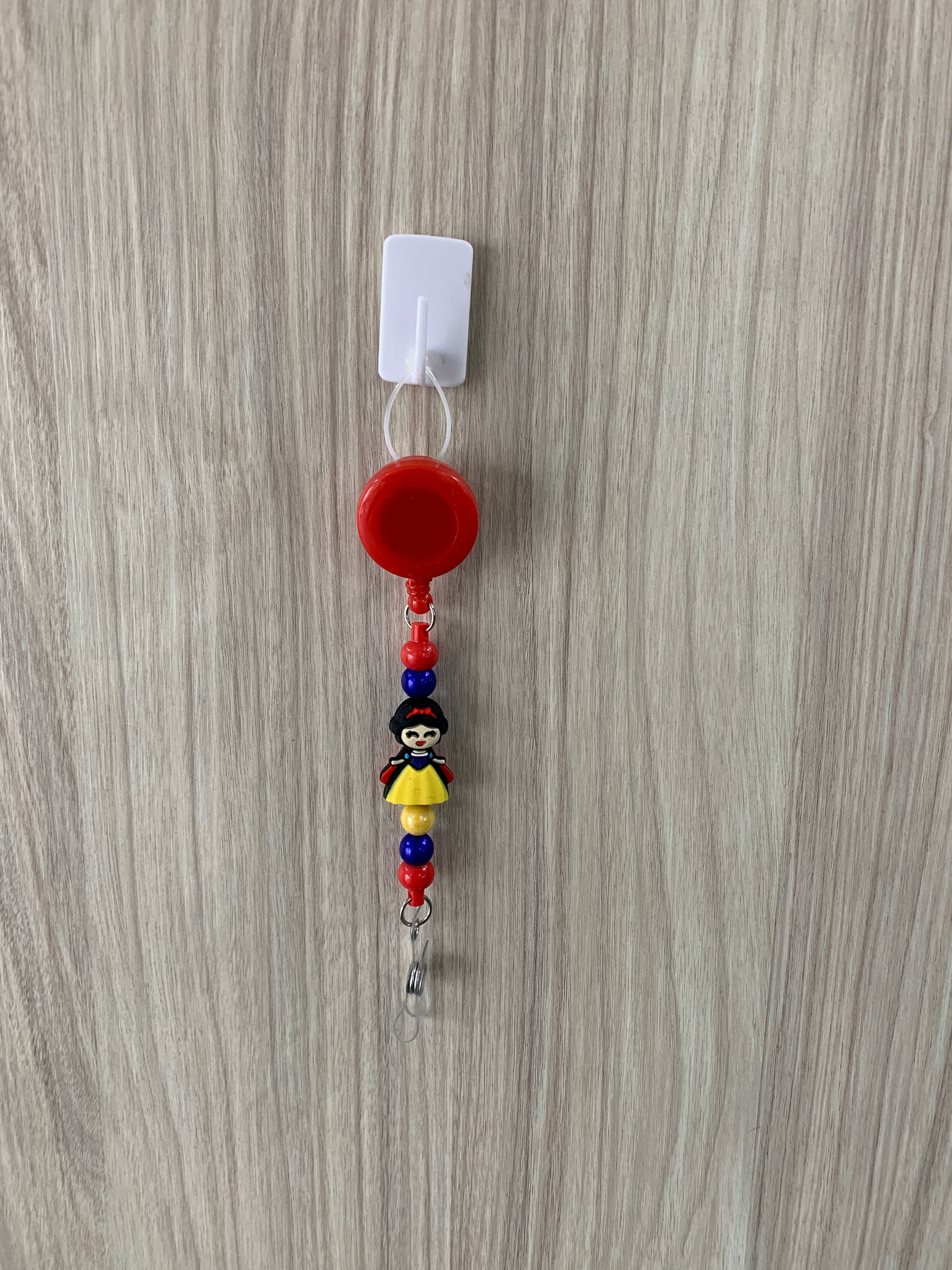 Handmade red princess beaded belt clip with blue and yellow accents